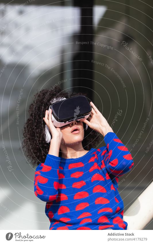 Fröhliche Frau mit VR-Brille fährt Karussell auf dem Spielplatz Virtuelle Realität Erfahrung aufgeregt Nervenkitzel virtuell Kreisverkehr Schutzbrille