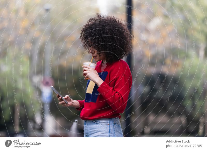 Schwarze Frau nimmt Selfie mit Becher Saft zum Mitnehmen Imbissbude Smartphone fotografieren Selbstportrait soziale Netzwerke Großstadt genießen ethnisch