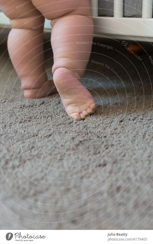 Kleinkind-Baby lernt zu stehen und zu gehen; Kind macht einen Schritt, der die Fußsohle zeigt Lernen Sohle Spaziergang Gleichgewicht Kilometerstein Entwicklung