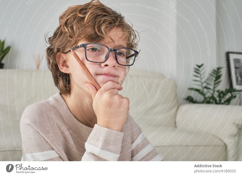 Ausdrucksstarkes Jungenportrait Porträt kleiner Junge Denken expressiv zu Hause gemütlich Blick auf die Front Brille Gedanken nachdenklich Hintergrund
