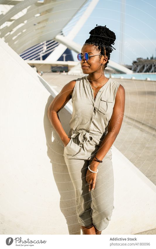 Glückliche schwarze Frau auf der Straße stehend ethnisch Afroamerikaner cool Sonnenbrille Stil Lächeln urban jung Optimist trendy froh positiv expressiv