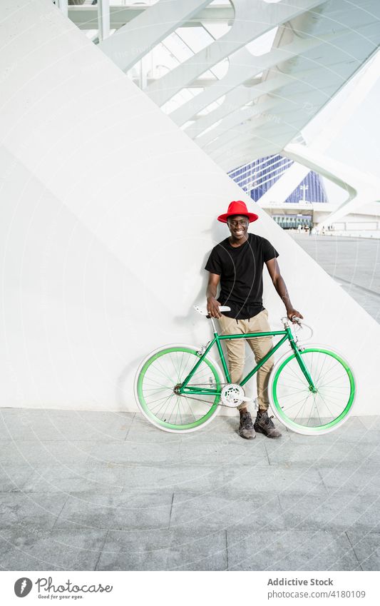 Stilvoller schwarzer Mann mit Fahrrad in der Stadt urban Großstadt jung modern trendy selbstbewusst männlich ethnisch Afroamerikaner Straße Vorschein Hipster