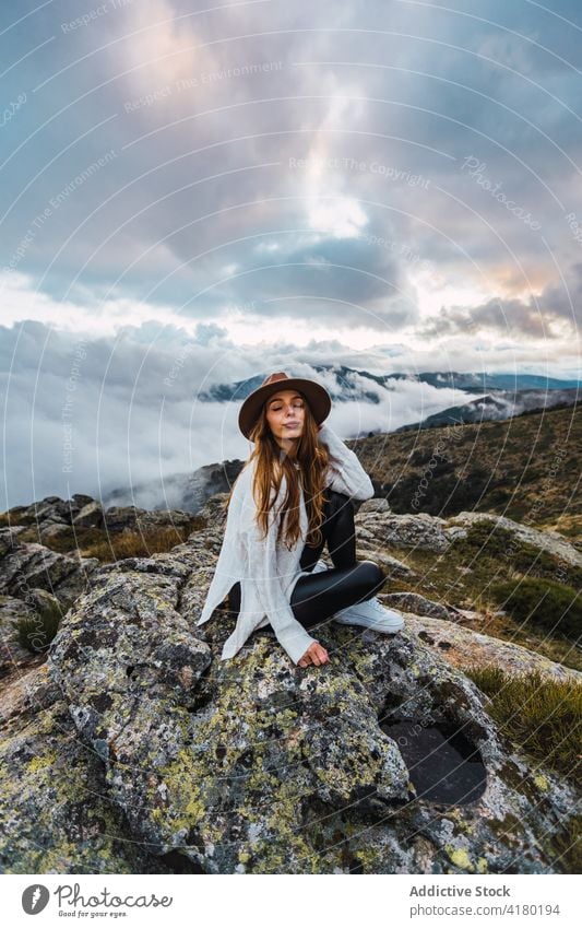 Frau mit Hut genießt den Blick auf die Berge Berge u. Gebirge beobachten Aussichtspunkt reisen Tourist Hochland bewundern erkunden Stein malerisch sitzen Natur