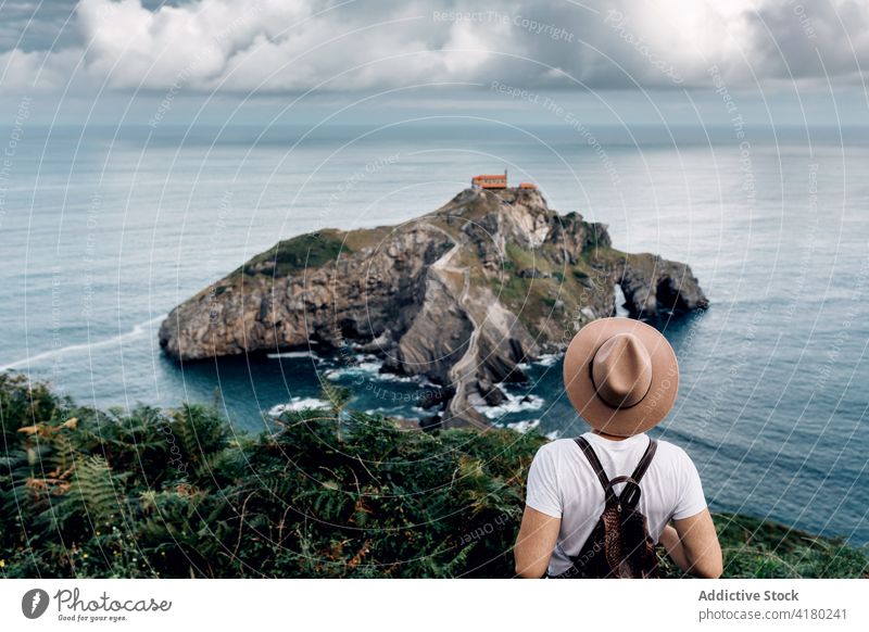 Reisender Mann steht und bewundert die Aussicht auf die Insel reisen beobachten MEER Urlaub Tourist Sommer männlich Gaztelugatxe Spanien Feiertag Wasser Meer