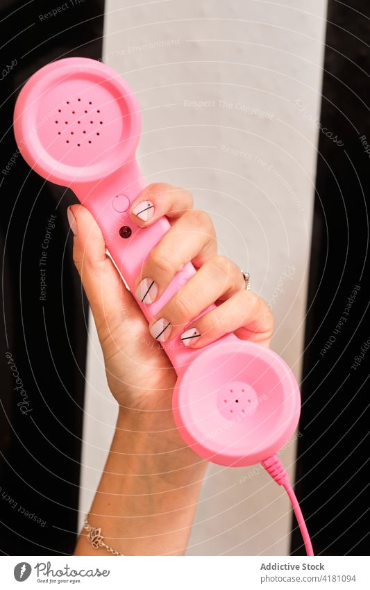 Frau mit stilvoller Maniküre hält Retro-Telefon Hand rosa retro Stil Design Farbe nageln Mode elegant Telefonhörer altmodisch altehrwürdig feminin Nagellack