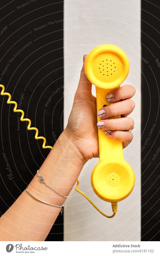 Frau mit stilvoller Maniküre hält Retro-Telefon Hand retro Stil Design Farbe nageln Mode elegant Telefonhörer altmodisch altehrwürdig feminin Nagellack