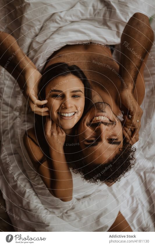 Glückliches unbekleidetes Paar sitzt Rücken an Rücken auf einer Decke heiter romantisch Zahnfarbenes Lächeln Liebe nackt kuscheln Zuneigung itim Partnerschaft
