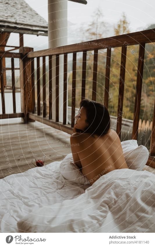 Oben-ohne-Frau auf Decke liegend auf Veranda Gelassenheit sich[Akk] entspannen Cottage Landschaft verträumt oben ohne Herbst Saison ruhig Komfort friedlich