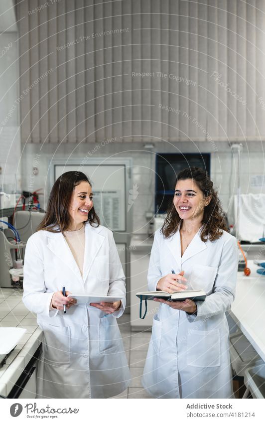 Fröhliche Wissenschaftler im Gespräch im Labor Kollege heiter reden diskutieren Glück positiv Frauen medizinisch Arbeit Zusammensein wissenschaftlich