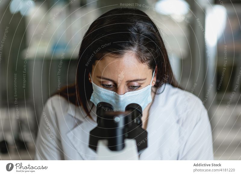 Wissenschaftlerin untersucht Testproben unter dem Mikroskop Labor untersuchen analysieren Gerät benutzend forschen Experiment Frau Chemikalie modern Arbeit