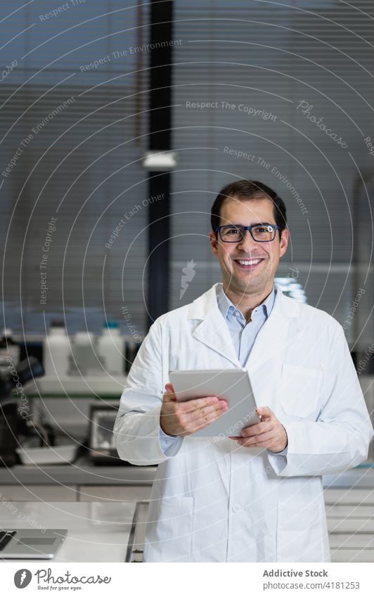 Mann im weißen Kittel bei der Arbeit im Labor Wissenschaftler forschen Pharma medizinisch Chemiker professionell Tablette Laptop Gerät wissenschaftlich Job