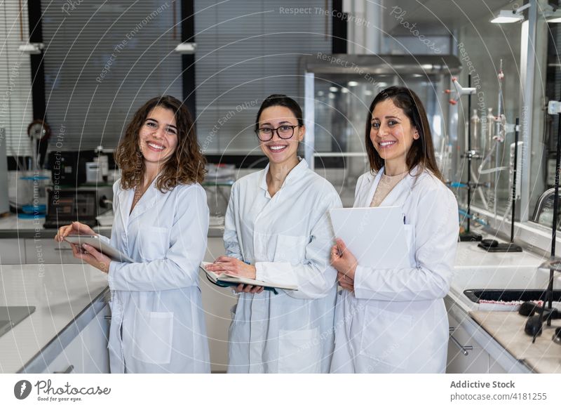 Lächelnde junge Wissenschaftler versammeln sich im Labor Kollege Menschengruppe medizinisch Zusammensein forschen Team professionell sich[Akk] sammeln heiter