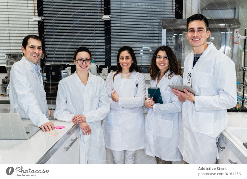 Lächelnde junge Wissenschaftler versammeln sich im Labor Kollege Menschengruppe medizinisch Zusammensein forschen Team professionell sich[Akk] sammeln heiter