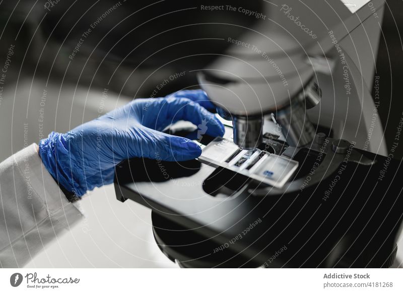 Wissenschaftler untersucht chemische Probe unter dem Mikroskop Labor untersuchen analysieren Gerät forschen Experiment Chemikalie Analyse professionell Hand
