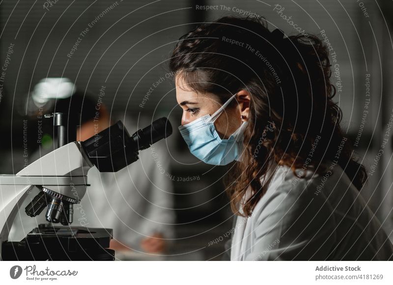 Wissenschaftlerin untersucht Testproben unter dem Mikroskop Labor untersuchen analysieren Gerät benutzend forschen Experiment Frau Chemikalie modern Arbeit