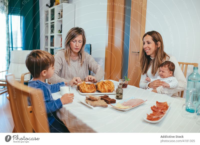 Lesbische Familie mit Kindern beim gemeinsamen Frühstück lesbisch Sohn Baby Mahlzeit Partnerschaft Einheit lgbt Mutterschaft Frauen Homosexualität Kindheit