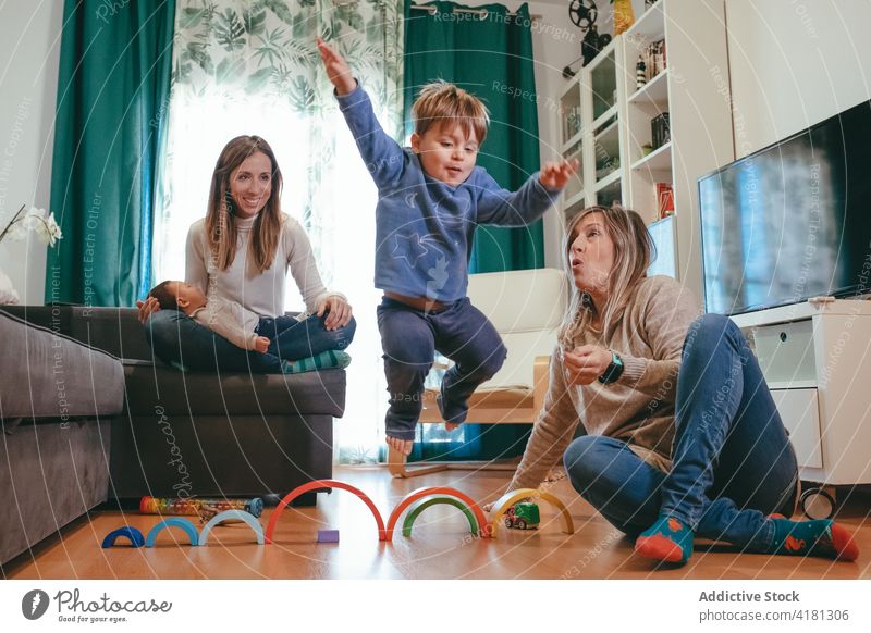 Fröhliche homosexuelle Familie spielt mit süßen Kindern zu Hause Paar lesbisch spielen Homosexualität Glück Spaß haben Freizeit Wohnzimmer sorgenfrei Eltern