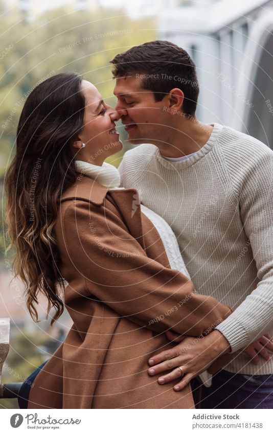 Verliebtes Paar in Oberbekleidung umarmt sich auf der Straße Umarmung Umarmen romantisch warme Kleidung heiter Liebe amourös Zuneigung Herbst Partnerschaft