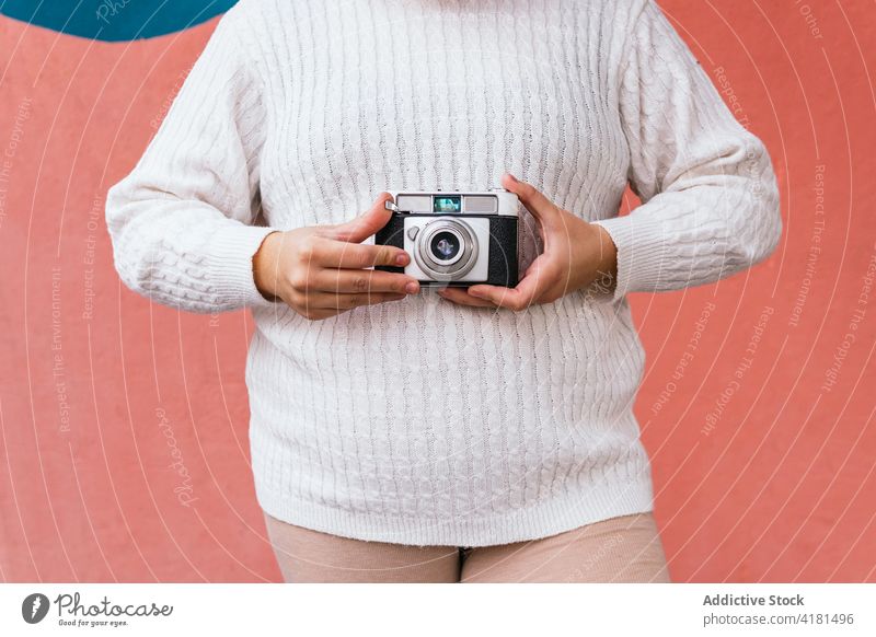 Unbekannter Fotograf fotografiert mit Kamera in der Nähe einer Mauer im Freien fotografieren Fotoapparat digital Fokus Linse Gedächtnis Frau Moment benutzend