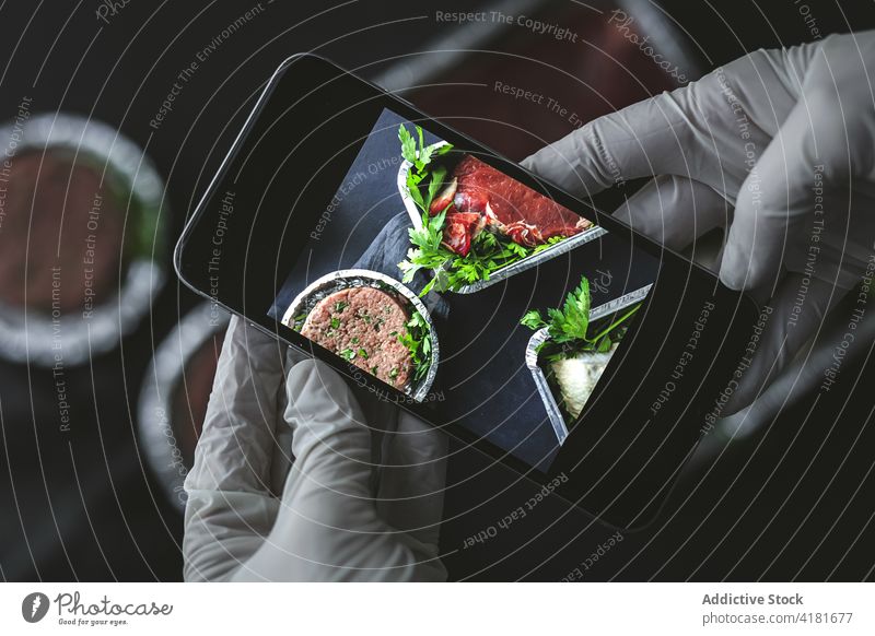 Person, die rohes Fleisch mit dem Smartphone fotografiert Koch fotografieren Imbissbude praktisch Food-Fotografie Container Paket Dienst Einmalgebrauch
