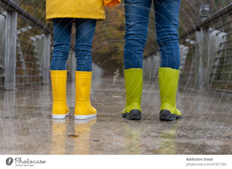 Kinder in Gummistiefeln stehen bei Regen auf einer Brücke Herbst Bein Zusammensein Wetter Park farbenfroh fallen Natur Saison Stil Farbe hell lebhaft gelb grün