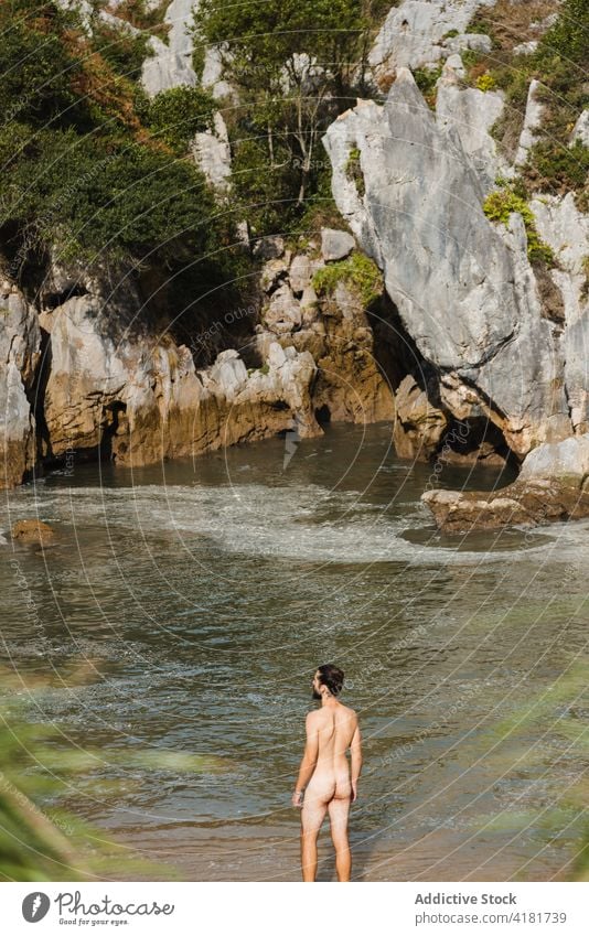 Unbekannter nackter Mann am Seeufer im felsigen Hochland Strand Felsen rau FKK Klippe sich[Akk] ausziehen stehen Teich malerisch Natur Asturien Spanien Ufer