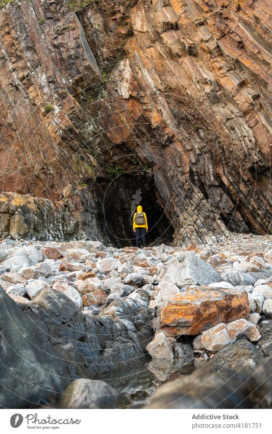 Unbekannter Reisender steht in der Nähe einer Felsenhöhle Person rau Höhle Grotte steif Berge u. Gebirge Stein Formation Gelände Hochland Klippe malerisch