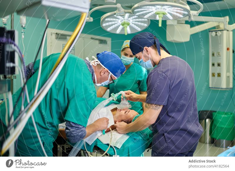 Nicht erkennbarer männlicher Arzt, der einem auf der Liege liegenden Patienten vor der Operation eine Anästhesie verabreicht Mann Ärzte geduldig Operationssaal