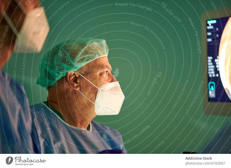 Unkenntlich gemachte Chirurgen bei der diagnostischen Endoskopie im Operationssaal Diagnostik Krankenhaus Monitor Menschen untersuchen Arzt professionell Klinik