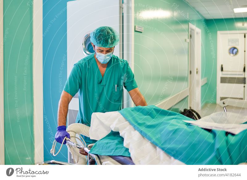 Anonymer Krankenpfleger, der eine Bahre nach einer Operation trägt Mann führen Trage Krankenhaus Flur geduldig Praktiker Chirurgie dringend Klinik Arzt männlich