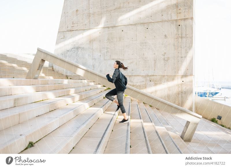 Aktive Sportlerin, die in einem Vorort die Treppe hinaufläuft laufen nach oben Treppenhaus Vorstadt Vitalität sportlich Bestimmen Sie Herz Ausdauer Frau