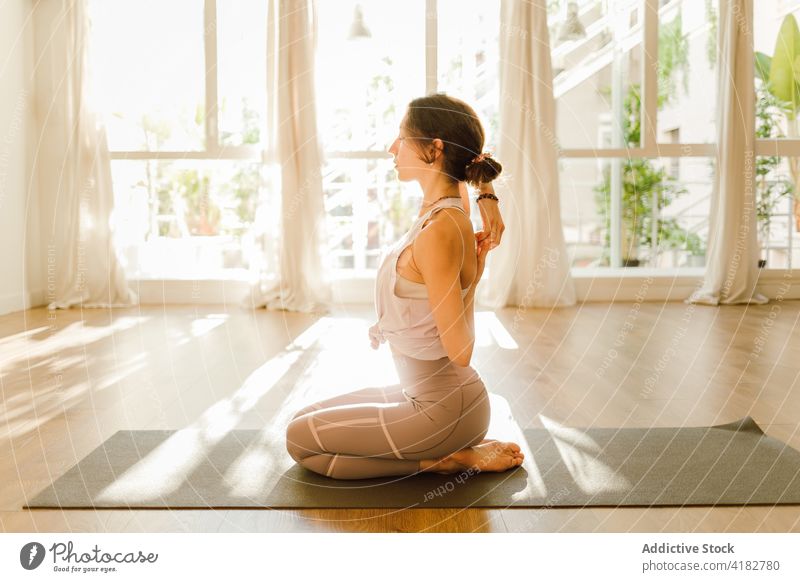 Konzentrierte Frau, die ihre Arme in Thunderbolt-Pose zu Hause ausstreckt Dehnung Yoga Hand hinter dem Rücken üben Gesunder Lebensstil Energie Augen geschlossen