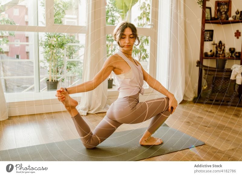 Barfuß Frau streckt Bein auf Knie zu Hause üben Yoga Dehnung Tastfuß Wellness Gesunder Lebensstil Energie Gleichgewicht heimwärts Vitalität Unterlage Körper