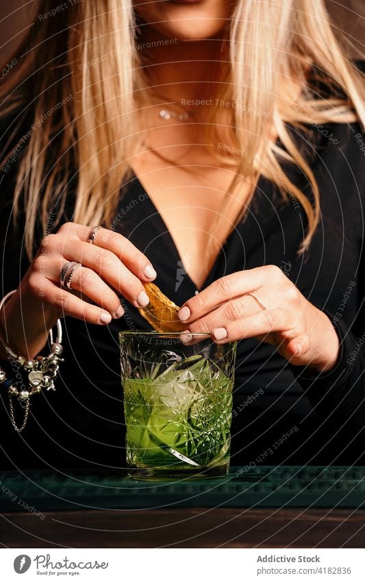 Stilvolle junge Frau bei der Zubereitung eines alkoholischen Cocktails in einer modernen Bar vorbereiten Alkohol trinken Barkeeper Getränk trendy Fokus