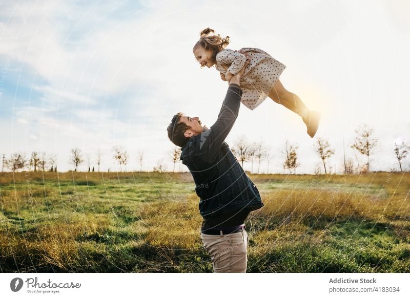 Vater spielt mit Tochter auf einem Feld spielen Kind werfen Spaß haben Zusammensein Wochenende Landschaft sonnig heiter niedlich wenig Mädchen Eltern