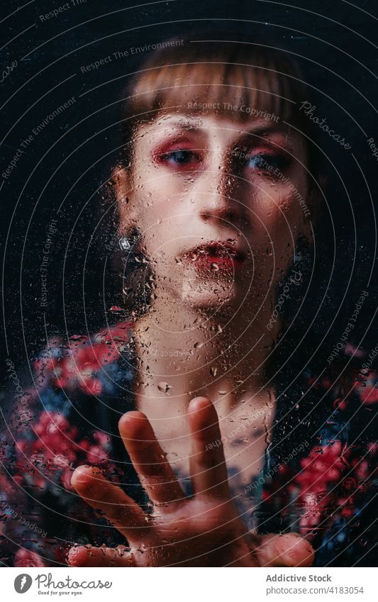 Melancholische Frau mit Make-up berührt Glas mit Wassertropfen Melancholie Depression traurig Tropfen Einsamkeit hoffnungslos Porträt sanft Ornament Knall