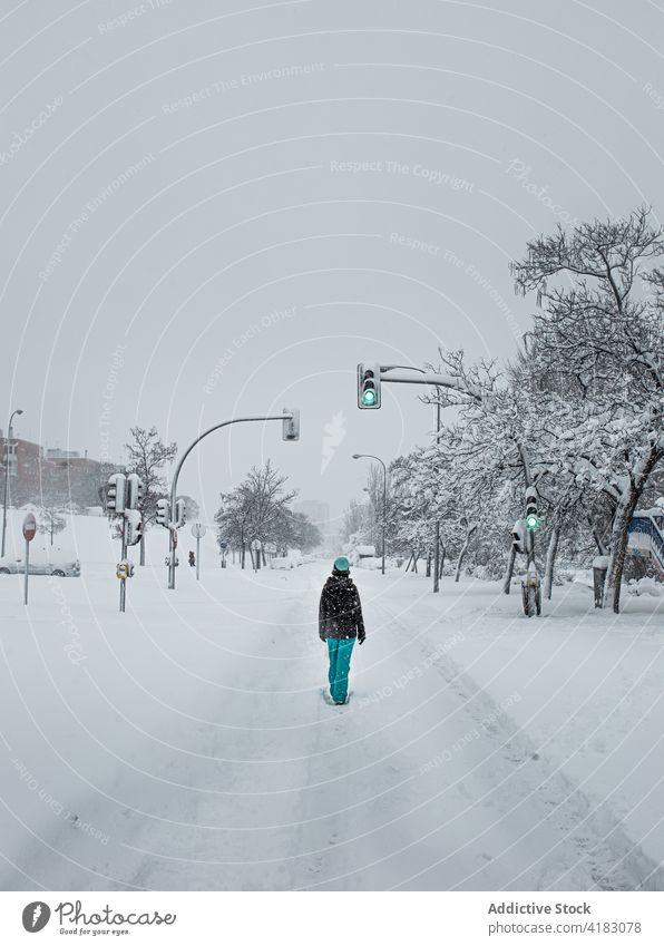Unbekannte Person auf verschneiter Straße in winterlichem Vorort Spaziergang Winter Schnee kalt Ampel Vorstadt schlendern warme Kleidung Saison Weg Frost