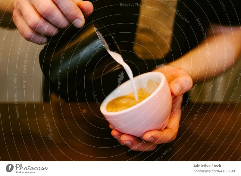 Nahaufnahme eines Kellners, der Milch zu einer Tasse Kaffee serviert Dienst trinken Café Kantine professionell Kannen Restaurant Person Espresso heiß Getränk