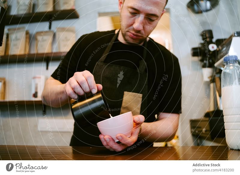 Nahaufnahme eines Kellners, der Milch zu einer Tasse Kaffee serviert Dienst trinken Café Kantine professionell Kannen Restaurant Person Espresso heiß Getränk