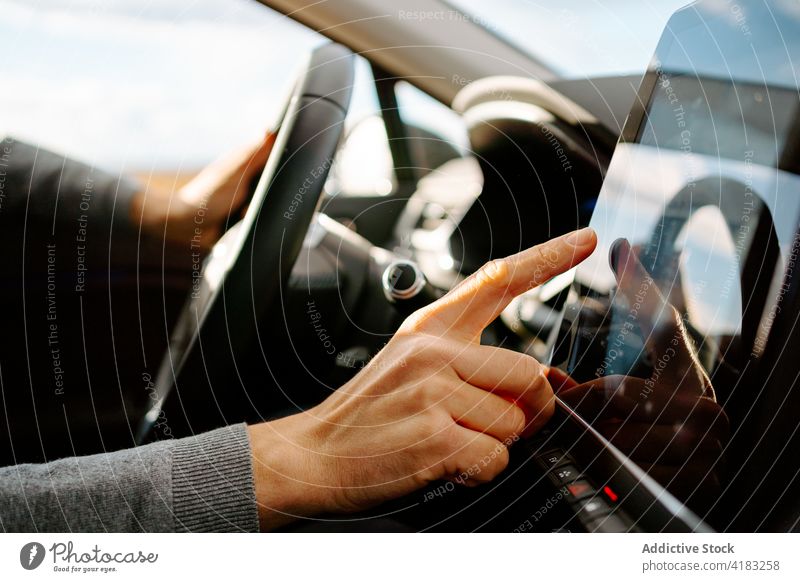 Anonymer Mann benutzt GPS-Navigator, während er ein zeitgenössisches Auto fährt Laufwerk PKW Gps Touchscreen Fahrer Gerät Monitor Autoreise sich orientieren