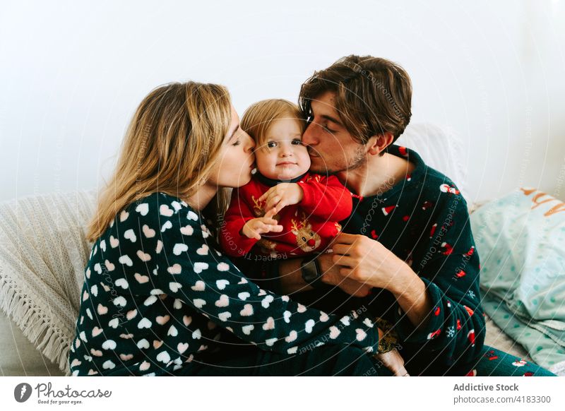 Mutter und Vater küssen ihr Kind auf die Wangen Familie Eltern Kuss Kleinkind Angebot Liebe Zusammensein heimwärts Zuneigung Bonden Pyjama schließen niedlich