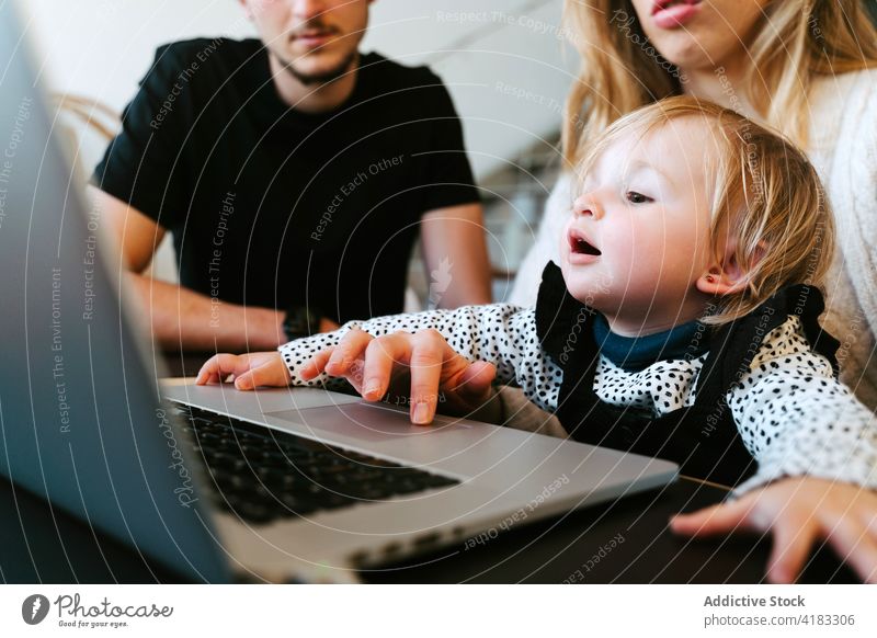 Familie schaut sich zu Hause gemeinsam einen Film auf dem Laptop an zuschauen Kleinkind heimwärts Wochenende Paar wenig Kind Tisch Zusammensein Bonden sitzen