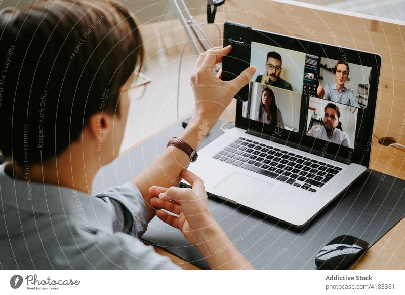 Fröhlicher Mann führt Videogespräch mit Arbeitskollegen Videoanruf Coronavirus heimwärts online Tagung Video-Chat Mitarbeiter neue Normale männlich