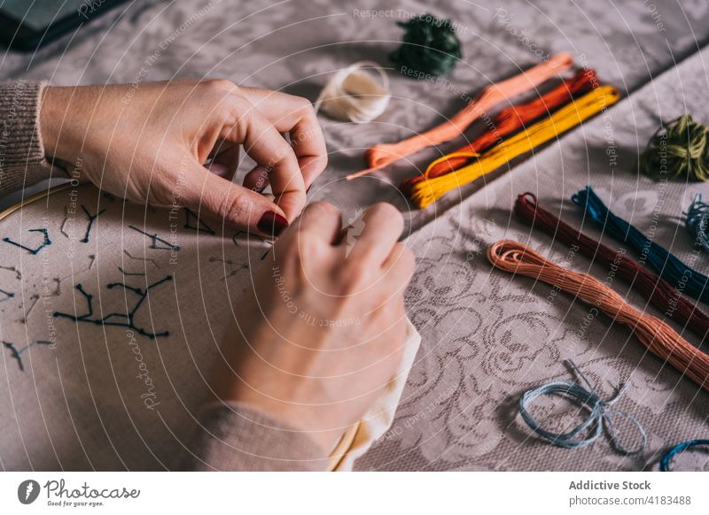 Gesichtslose Frau, die zu Hause mit einem Stickrahmen stickt Stickereien Reifen handgefertigt Faser Fähigkeit Hobby Handarbeit sticken diy Prozess Werkstatt