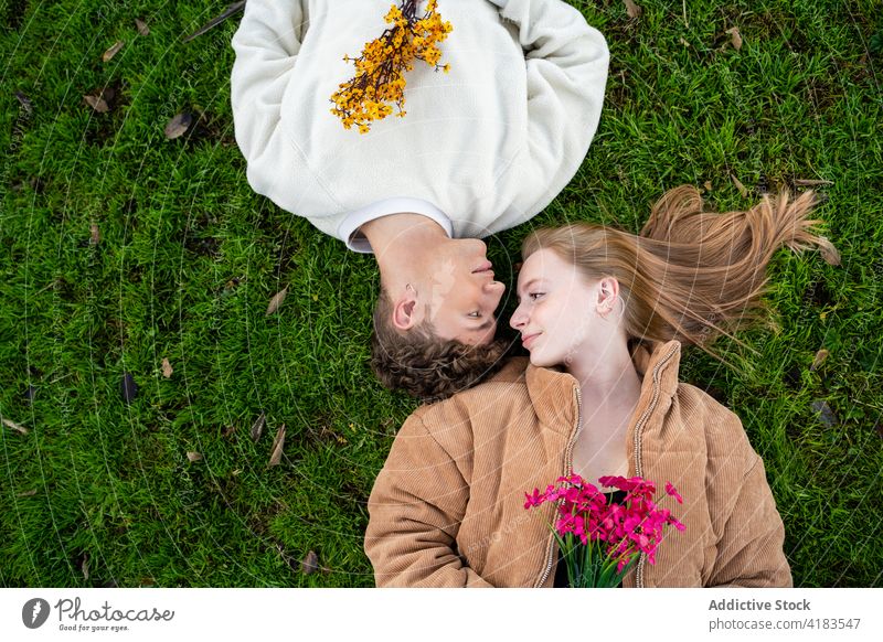 Pärchen mit blühenden Blumen auf einer Wiese liegend Paar sich[Akk] entspannen Rasen Partnerschaft Liebe sanft Zeit verbringen Sommer idyllisch ruhen freie Zeit