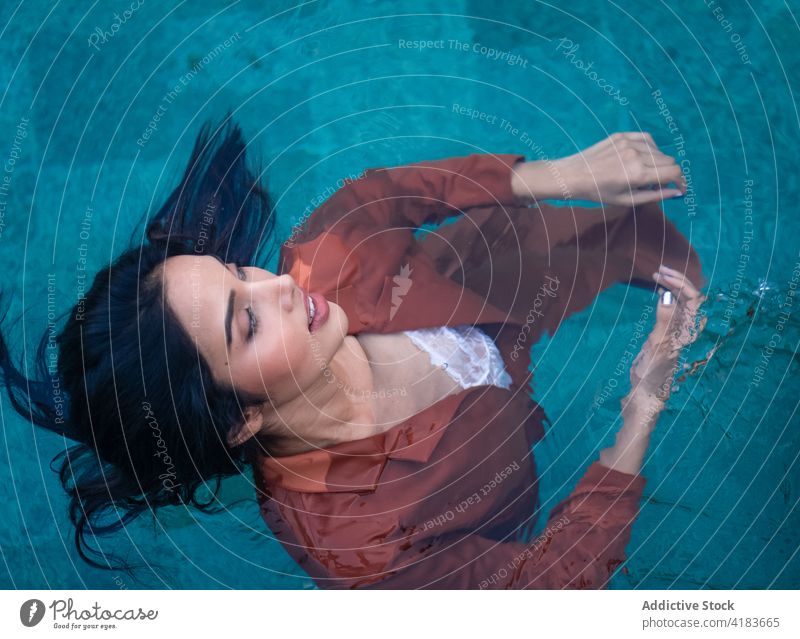 Sinnliche Frau schwimmt im Wasser eines Sees sich[Akk] entspannen Schwimmer ruhig genießen Natur Gelassenheit Harmonie jung ethnisch tropisch ruhen Windstille