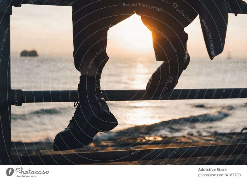 Unbekannter Reisender ruht sich bei Sonnenuntergang am Meer aus MEER Bein ruhen Zaun winken Sonnenlicht sich[Akk] entspannen Abend Person Seeküste Herbst Natur