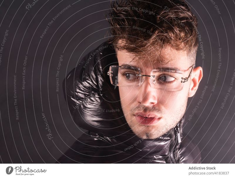 Nachdenklicher junger Mann in schwarzem Studio mit Rauch nachdenklich ernst Stil Vorschein besinnlich wehmütig Mode gutaussehend Menschliches Gesicht männlich