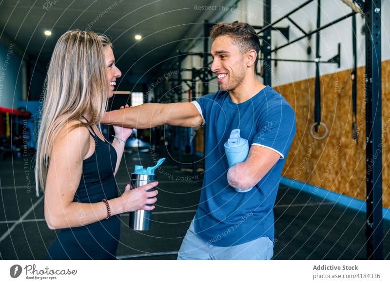 Sportler trinken ein Getränk während des Trainings in einer Sporthalle durstig Erfrischung Pause Mann Frau Wasser Flasche deaktiviert Fitnessstudio Zusammensein
