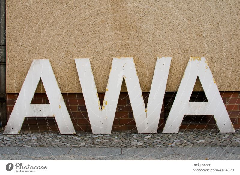 objektiv l einfach nur AWA Großbuchstabe Typographie Schilder & Markierungen Hauswand Bürgersteig Hintergrund neutral Abkürzung aufgestellt Klebereste